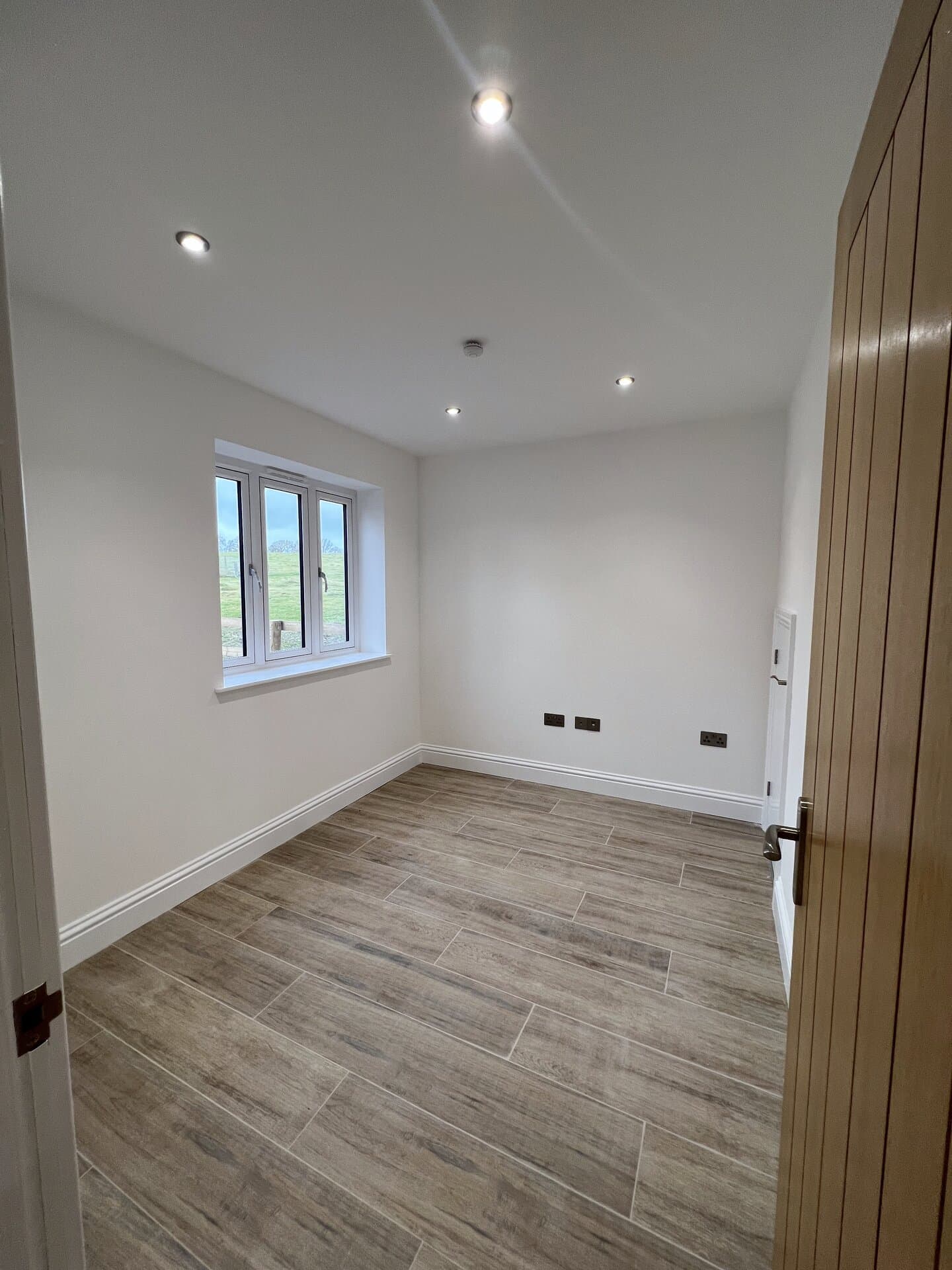 Re-plastered, repainted bedroom with wood-effect tile flooring throughout