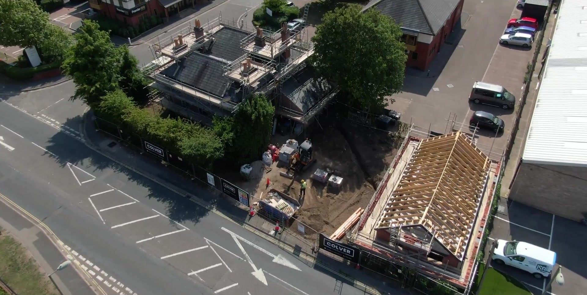 An aerial view of a site: a period building in scaffolding and a new build beside it